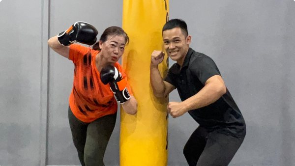 Amran coaching a member on the heavy bag