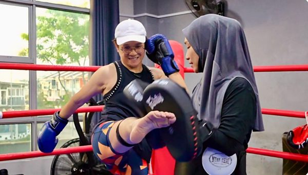 Emma coaching a member on the pads