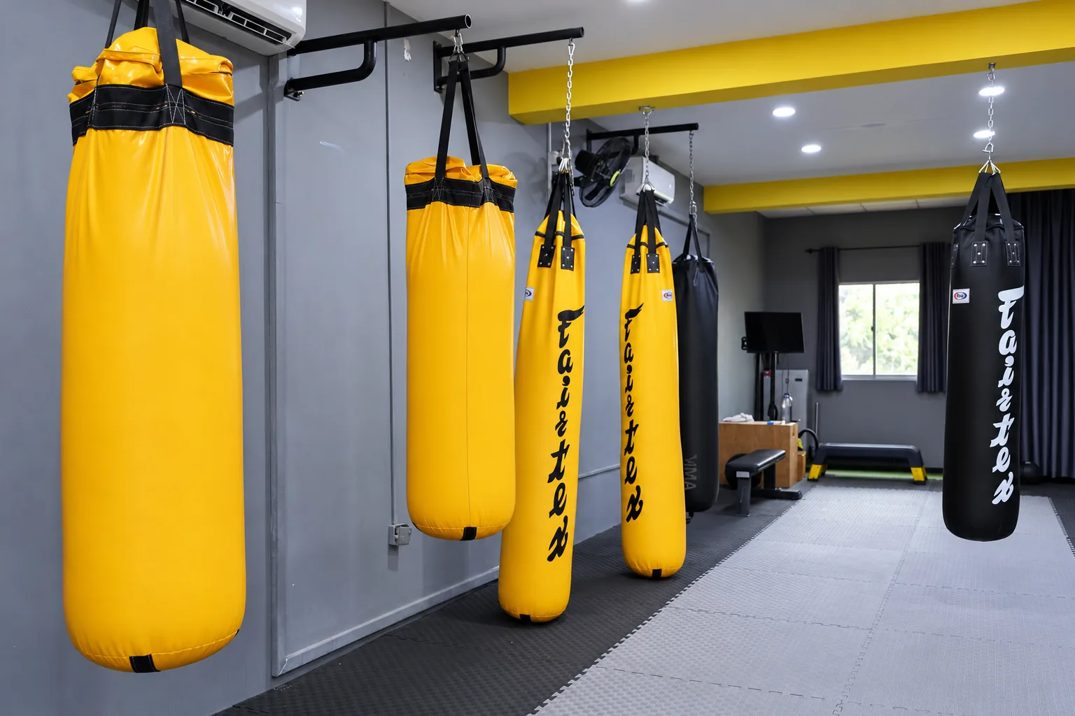 Heavy bags lined up at the Fitcom Muay Thai gym