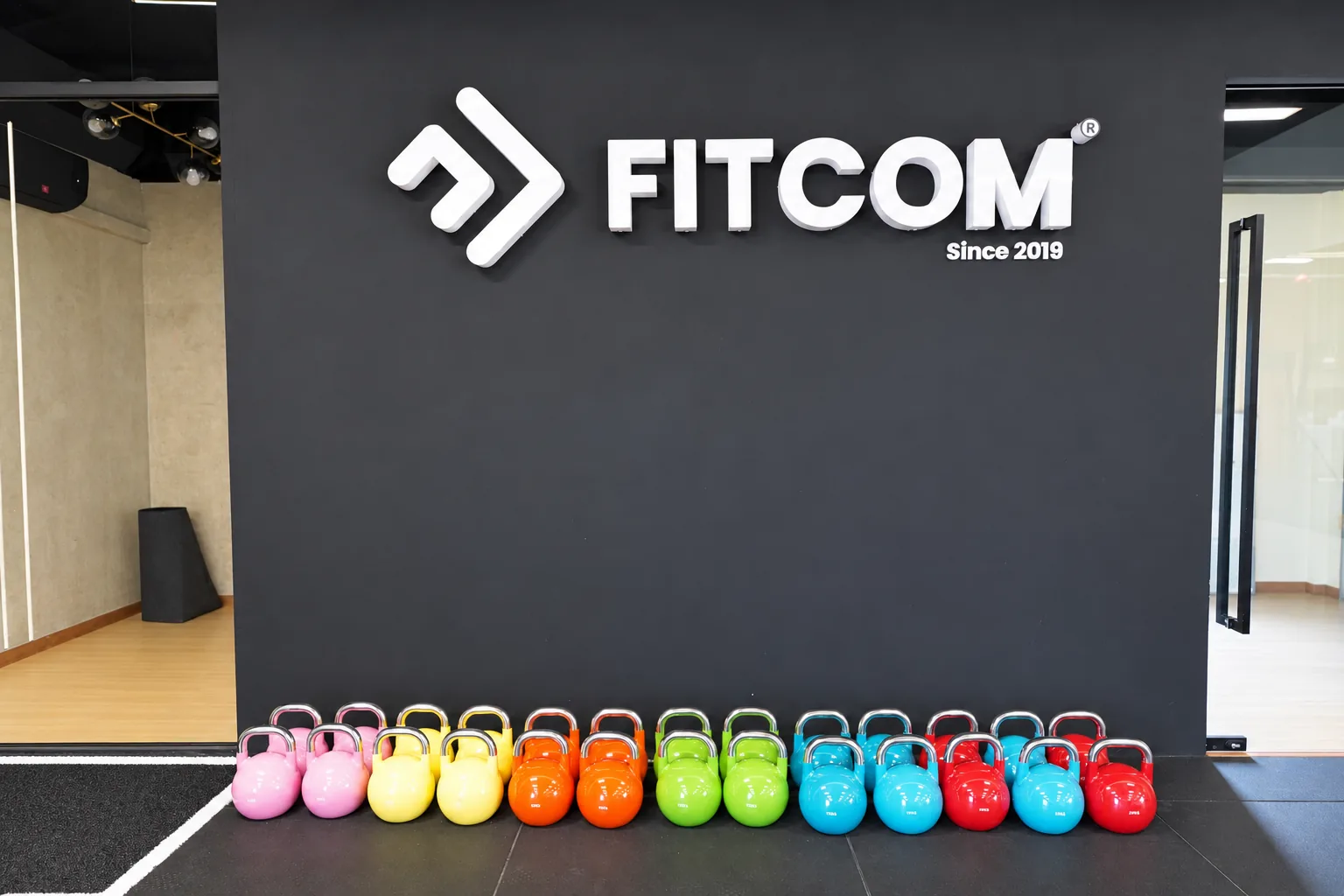 The Fitcom logo wall and the kettlebell row